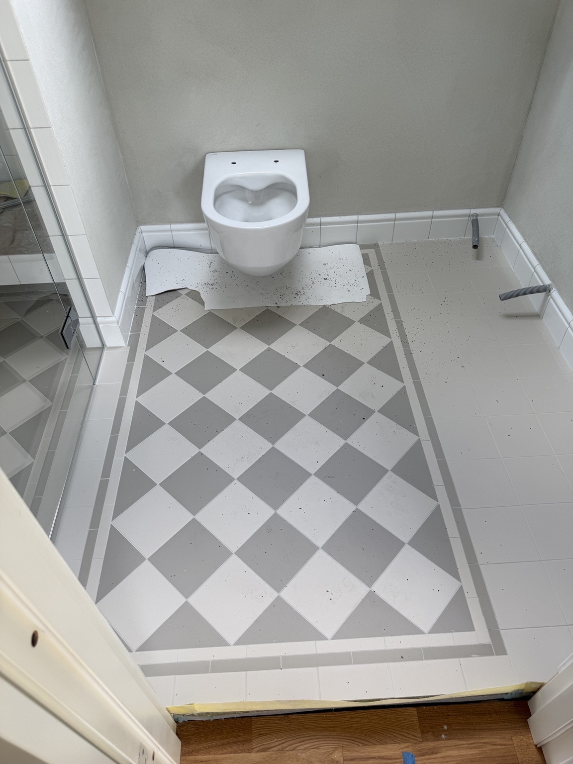 Mönsterlagt badrumsgolv och vägghängd WC under montering. Villa Stocksund.