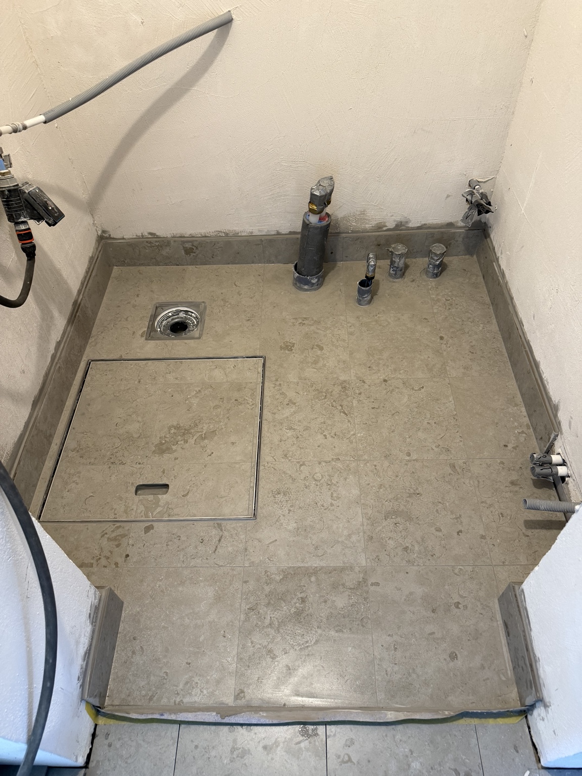Plattlagt golv med infälld lucka under arbetets gång. Villa Stocksund.